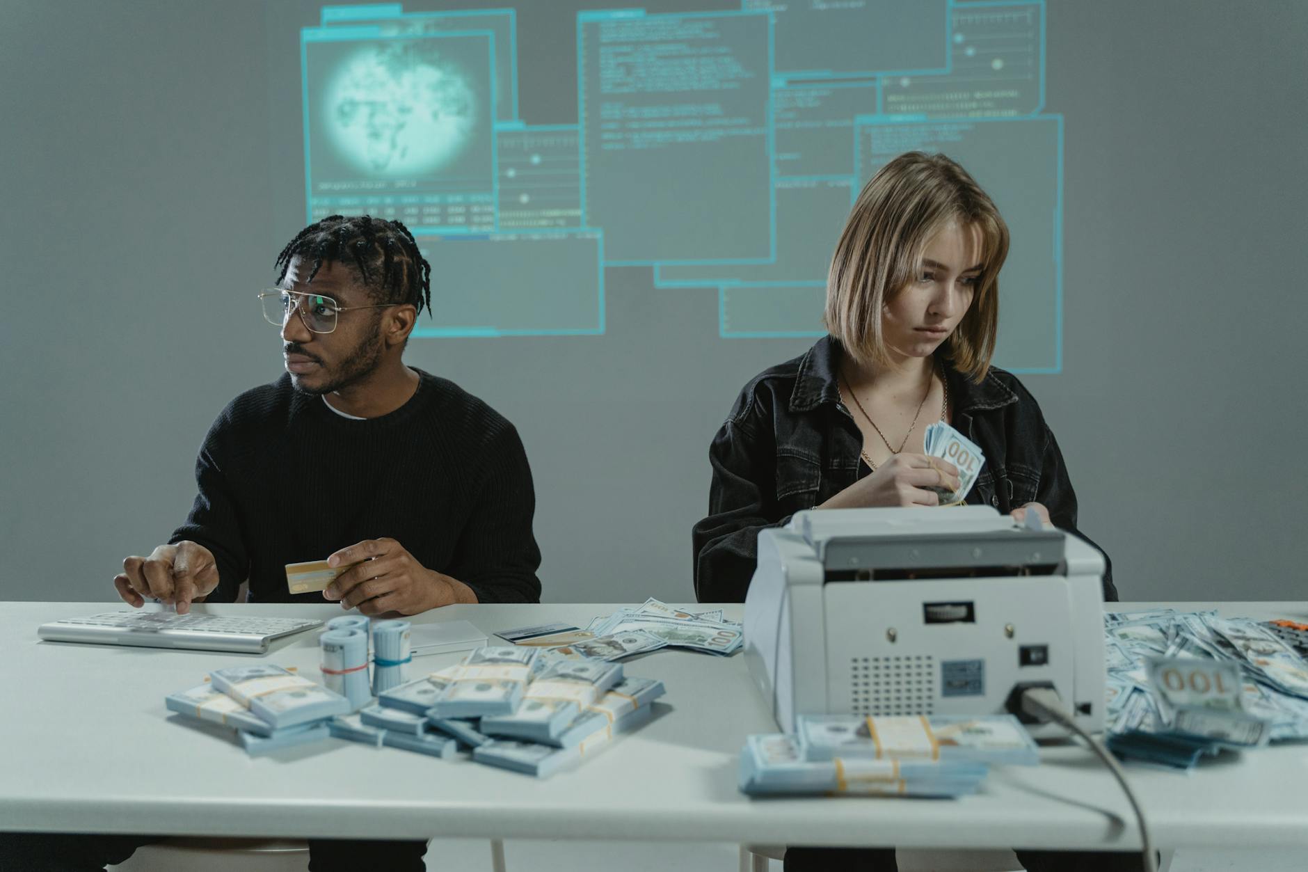 Two people counting money at a table representing real ways to make money with AI tools in 2026
